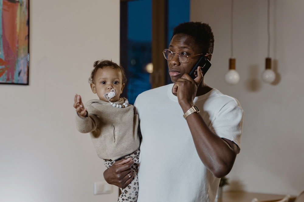 Father holding baby while on Cell Phone