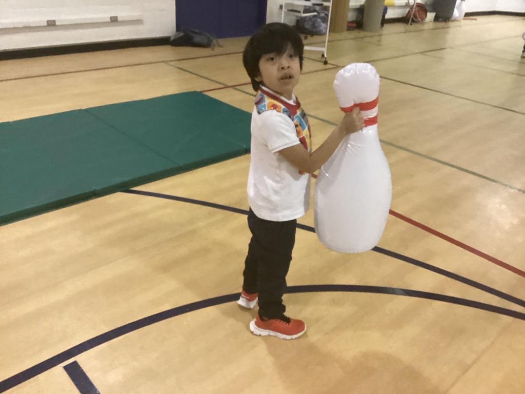 student holding a large inflatable bowling pin
